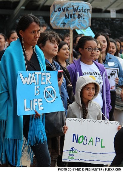 Young protestors hold signs that read "Water is Life" and "No DAPL."