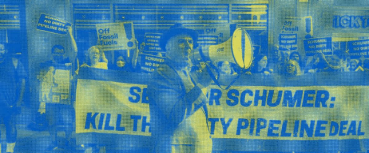 Food & Water Watch's New York organizer Eric Weltman stands with a bullhorn in front of a crowd of protestors.