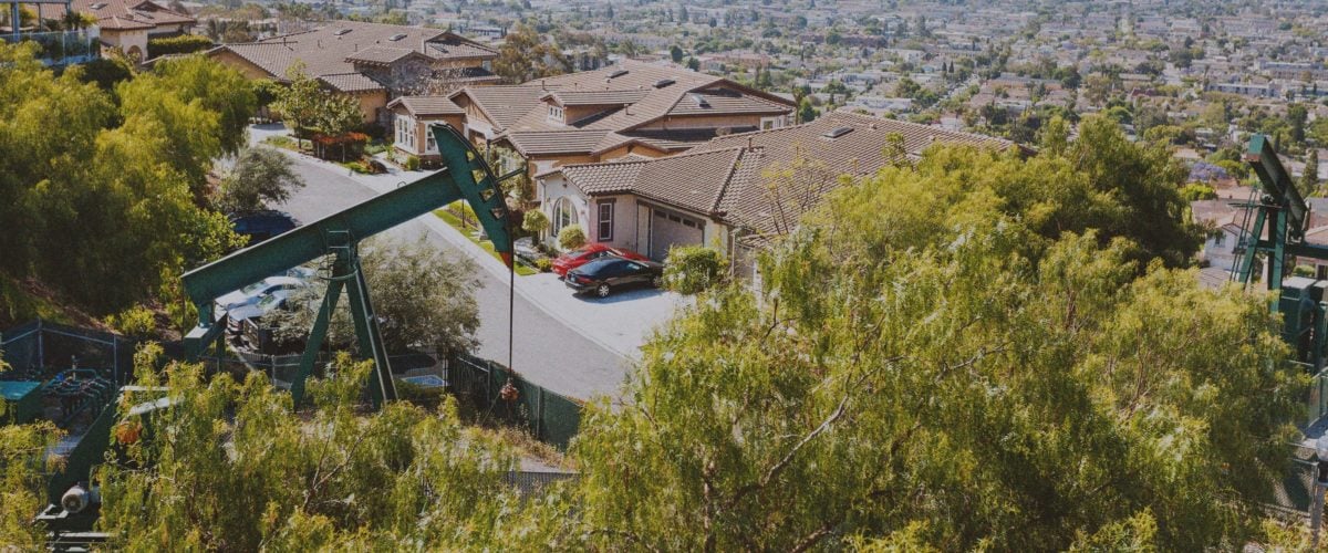 An oil donkey looms over a residential neighborhood in Los Angeles. These will soon be no more, as the City banned all new oil drilling with plans to phase out existing operations.