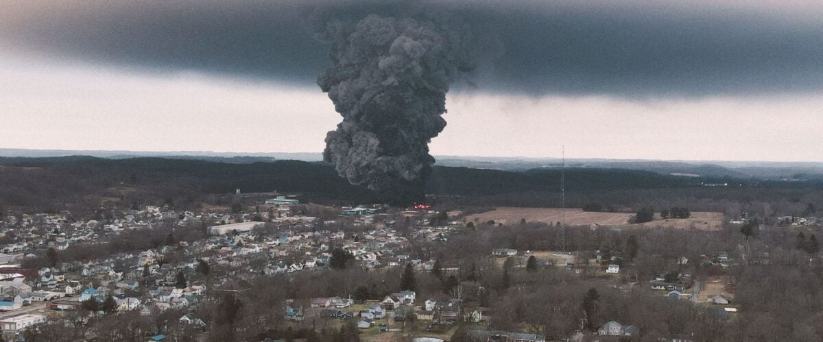 A dark plume of smoke and pollution rises high over the landscape of East Palestine, Ohio.