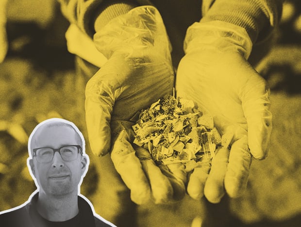 In the background, a pair of gloved hands holds out a pile of tiny plastic pieces. In the foreground, guest speaker Matt Simon.