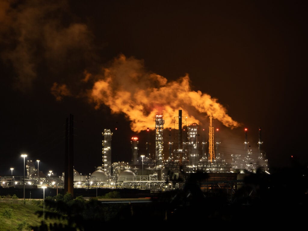 The glowing towers of Shell Polymers Monaca and a cloud of orange smoke and fire light up a pitch-black night.