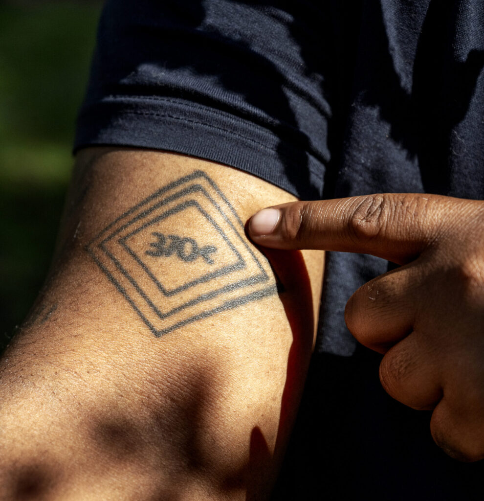 Vic Barett points to his tattoo, which reads "370c" enclosed in three diamonds.