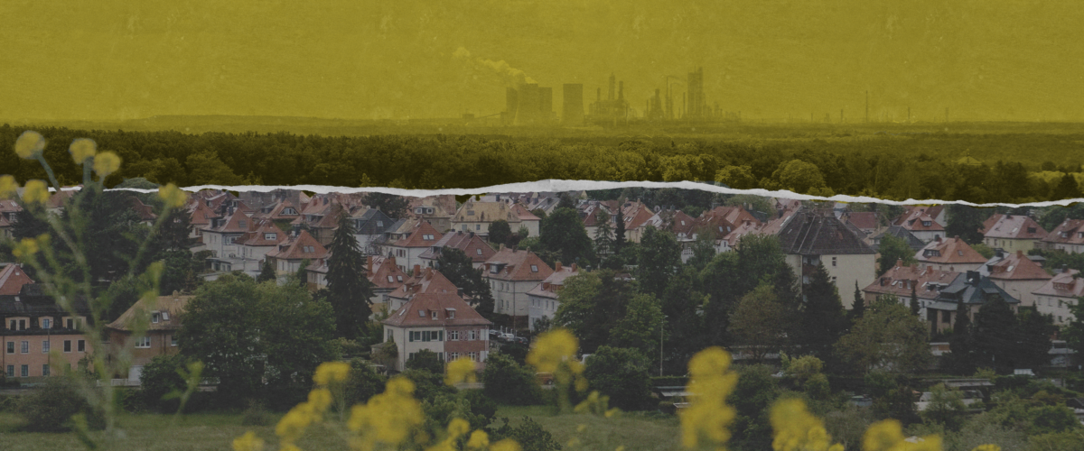 Smokestacks from a gas plant loom over a suburban neighborhood.