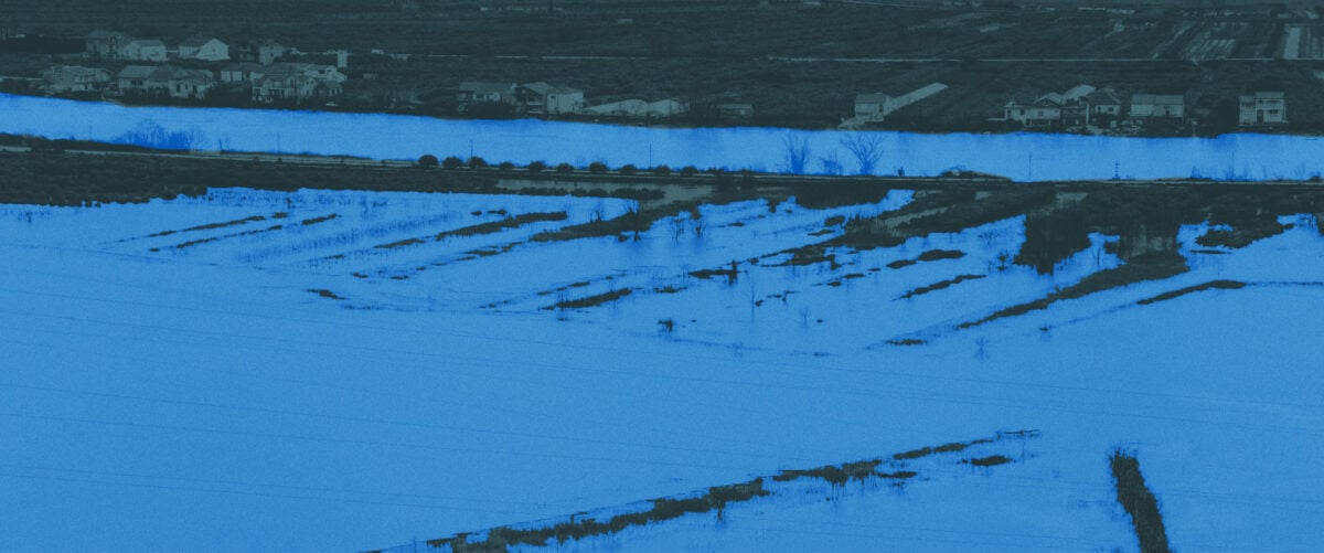 Water covers a rural neighborhood and fields.
