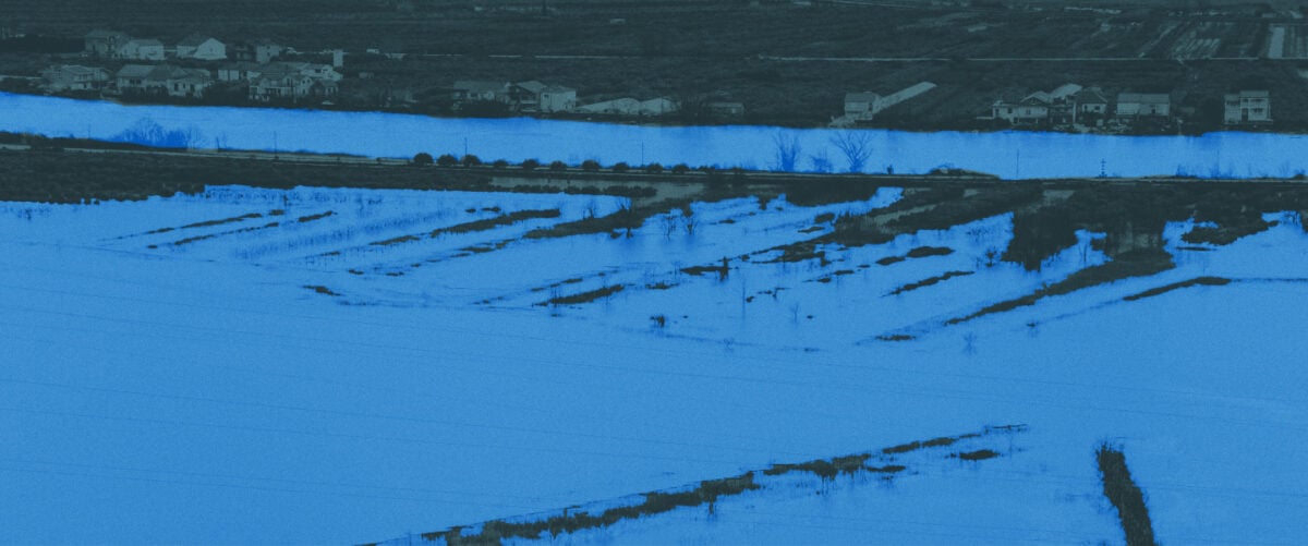 Water covers a rural neighborhood and fields.