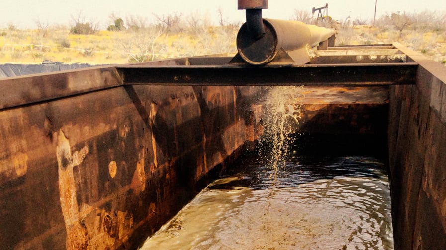 What Do PFAS Have to do With Fracking? [A color photo depicts murky and questionable looking water draining from fracking apparatus.]