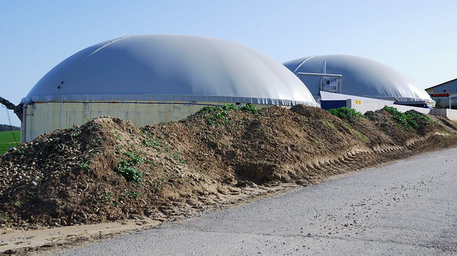 Two domed digesters sit beside a road.