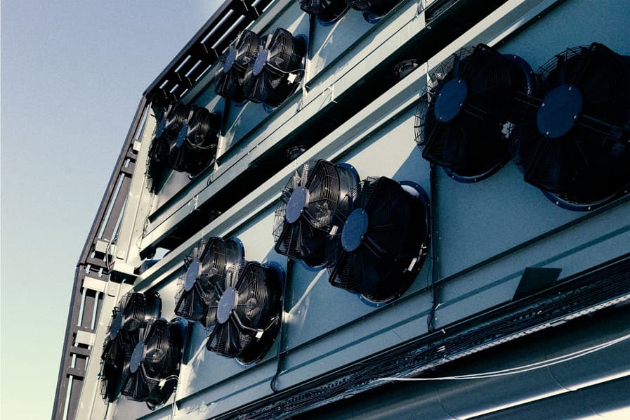 The fans on the side of a silver, rectangular direct air capture system.