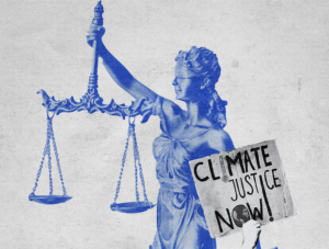 A statue of a woman representing justice (blindfolded, lifting a pair of scales) next to a sign that says "climate justice now!"
