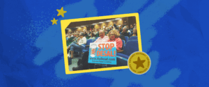 A photo of people gathered in an auditorium, with two people holding a sign that reads "STOP DESAL!"