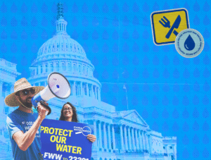 Protestors hold signs that say "Protect Our Water" in front of a photo of the U.S. Capitol