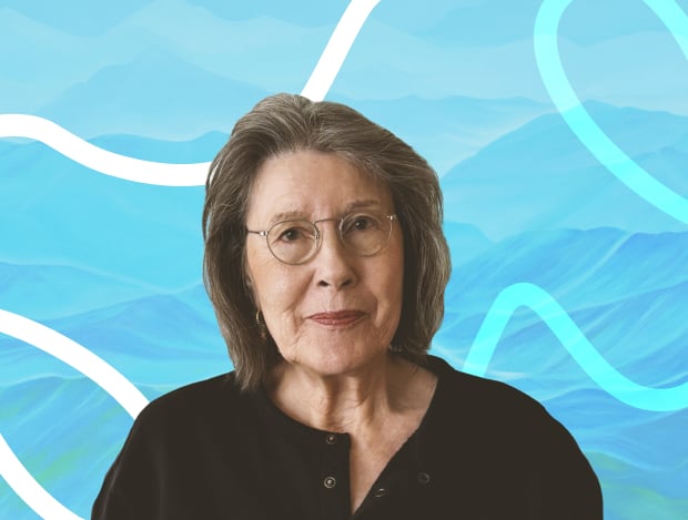 Fredericka Foster with one of her paintings in the background.